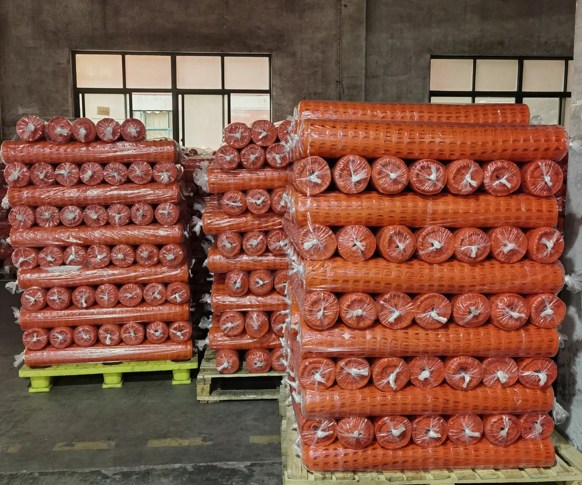 Packaged orange plastic safety fence rolls stacked in storage